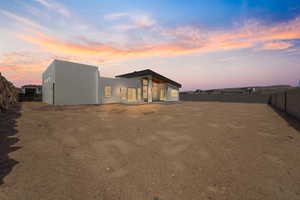 Rear view of property featuring a fenced backyard and stucco siding