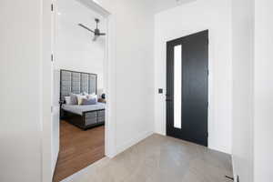 Foyer featuring baseboards, light marble finish flooring, and a ceiling fan