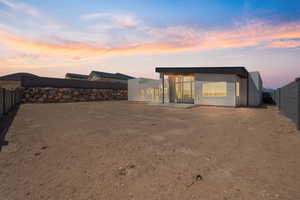 Back of house featuring a fenced backyard and stucco siding