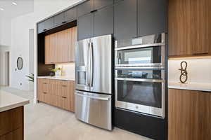 Kitchen with appliances with stainless steel finishes, light countertops, and modern cabinets