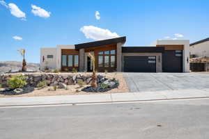 Contemporary house with a garage, driveway, stucco siding, and a mountain view