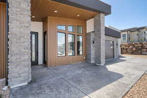 View of exterior entry with driveway and an attached garage