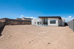 Rear view of property featuring a fenced backyard and stucco siding
