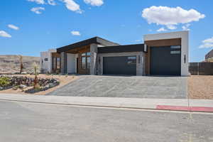 Modern home featuring an attached garage, driveway, and stucco siding