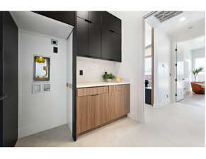 Kitchen with dark cabinets, light countertops, modern cabinets, and baseboards