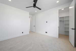 Unfurnished bedroom featuring recessed lighting, light colored carpet, a spacious closet, baseboards, and a closet