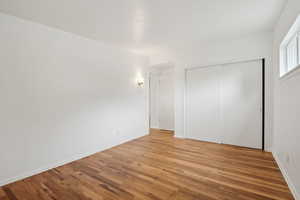 Unfurnished bedroom with light wood-style flooring, a closet, and baseboards