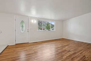Foyer with light wood-type flooring and baseboards
