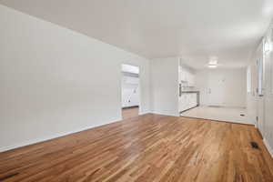Unfurnished living room with light wood finished floors and baseboards