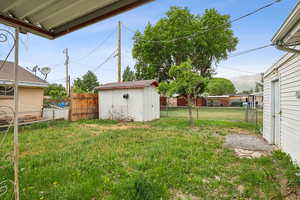 View of yard with a storage shed and an outdoor structure