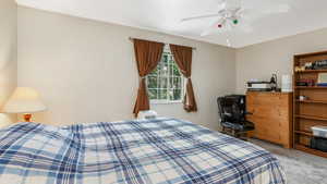 Bedroom with light colored carpet and ceiling fan