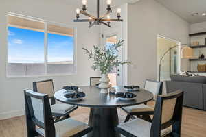 Dining area with a chandelier and light wood-style floors