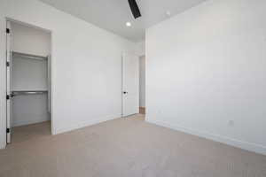 Unfurnished bedroom with light colored carpet, baseboards, a closet, and recessed lighting
