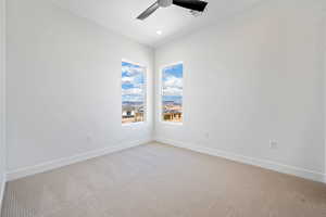 Spare room with ceiling fan, light carpet, and baseboards
