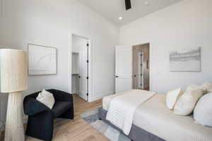 Bedroom with high vaulted ceiling, light wood-style flooring, a spacious closet, recessed lighting, and ceiling fan