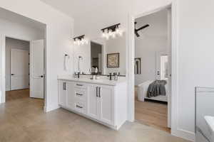 Ensuite bathroom featuring double vanity and wood finished floors