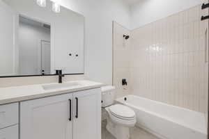 Full bathroom with toilet, vanity, shower / bath combination, and tile patterned flooring