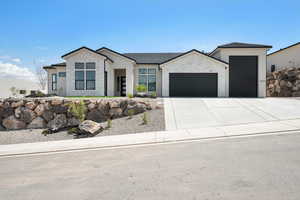 View of front facade featuring a garage, stone siding, driveway, stucco siding, and a tiled roof