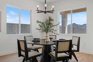 Dining space with a chandelier, light wood-style floors, and a mountain view