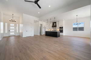 Kitchen with a chandelier, open floor plan, stainless steel appliances, premium range hood, and recessed lighting