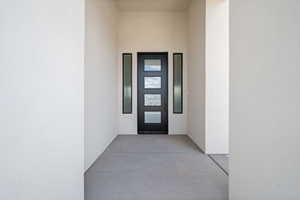 Doorway to property featuring stucco siding