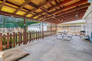 View of patio featuring a fenced backyard, a storage unit, and an outbuilding