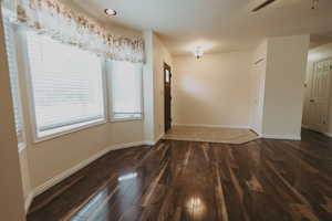 Unfurnished dining area featuring wood finished floors, baseboards, and a ceiling fan