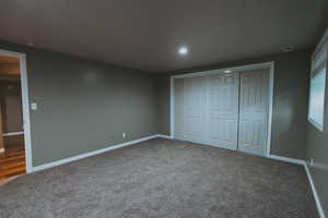 Unfurnished bedroom with carpet, baseboards, recessed lighting, and a closet