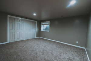 Unfurnished bedroom with carpet floors, baseboards, recessed lighting, and a closet