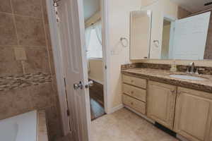 Full bath featuring vanity, baseboards, and tile patterned floors