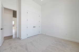 Unfurnished bedroom featuring carpet, a closet, and baseboards