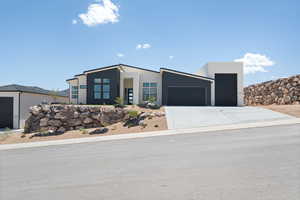 Contemporary house featuring a garage, driveway, and stucco siding