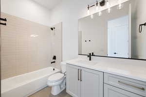 Bathroom featuring toilet, vanity, washtub / shower combination, and tile patterned floors