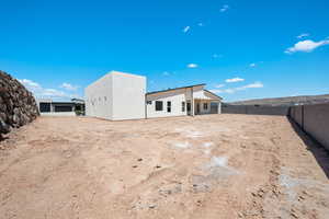 Rear view of property with stucco siding and a fenced backyard