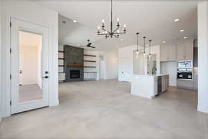 Kitchen featuring appliances with stainless steel finishes, a chandelier, decorative light fixtures, a sink, and a fireplace