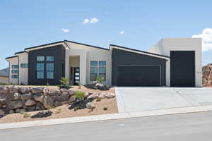 Modern home with a garage, concrete driveway, and board and batten siding