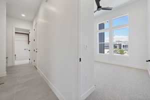 Hallway featuring baseboards, plenty of natural light, and recessed lighting
