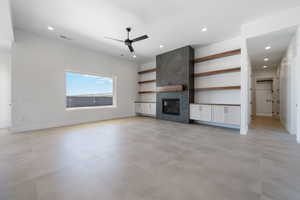 Unfurnished living room with a ceiling fan, recessed lighting, a tile fireplace, and baseboards