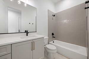 Bathroom with toilet, vanity, bathing tub / shower combination, and tile patterned flooring