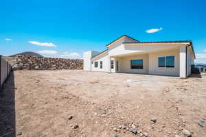 Rear view of property featuring stucco siding, a patio area, and fence