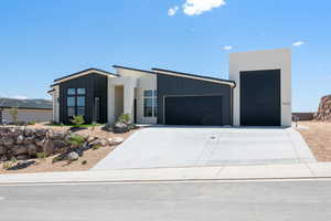 Contemporary house featuring board and batten siding, a garage, and driveway
