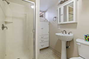 Full bath with a shower stall, toilet, and baseboards