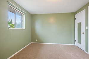 Empty room with carpet flooring and baseboards