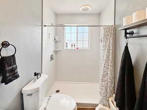 Full bath with toilet and a stall shower
