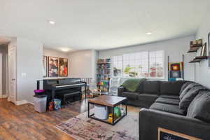 Living room featuring wood finished floors, recessed lighting, and baseboards