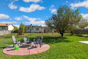 View of yard with an outdoor fire pit, and a patio area.