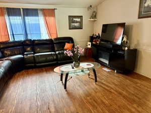 Living room with wood finished floors and crown molding