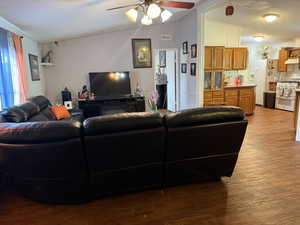 Living room featuring a textured ceiling, wood finished floors, and a ceiling fan