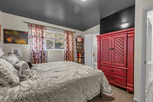 Primary Bedroom with carpet floors, lofted ceiling, and ensuite bathroom