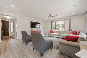 Living area featuring ceiling fan, light wood-style floors, baseboards, and recessed lighting